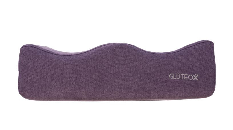 Cojín de tela morada con forma ondulada.